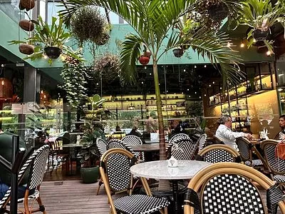 Lo Spuntini restaurant interior with marble tables, wicker chairs and palm trees